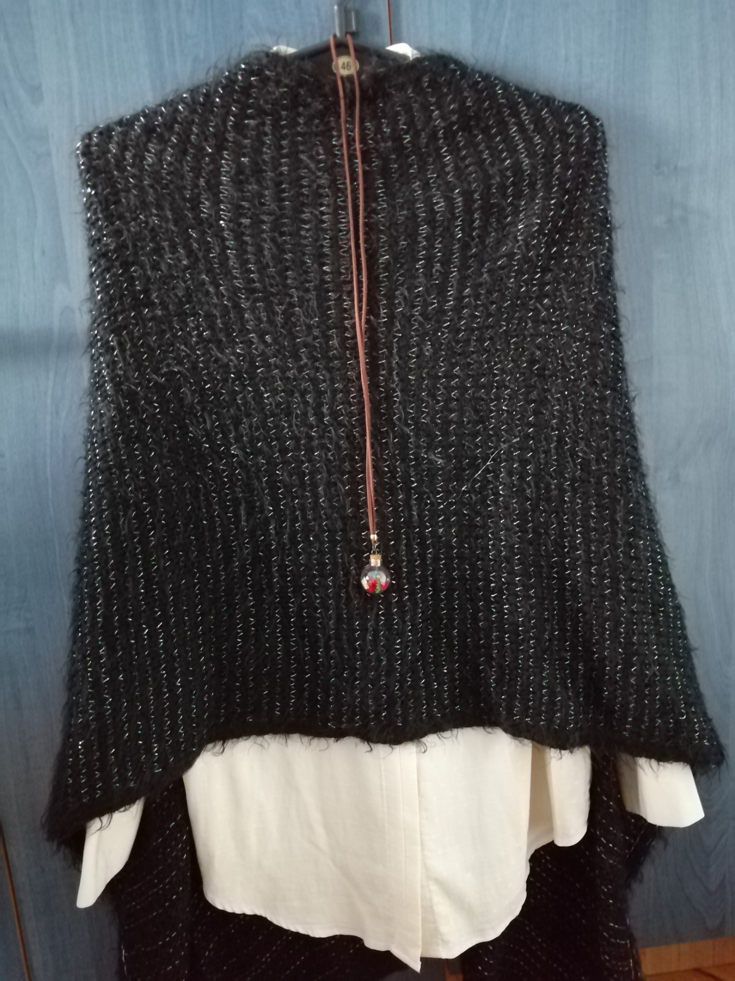 A white shirt with a knitted poncho