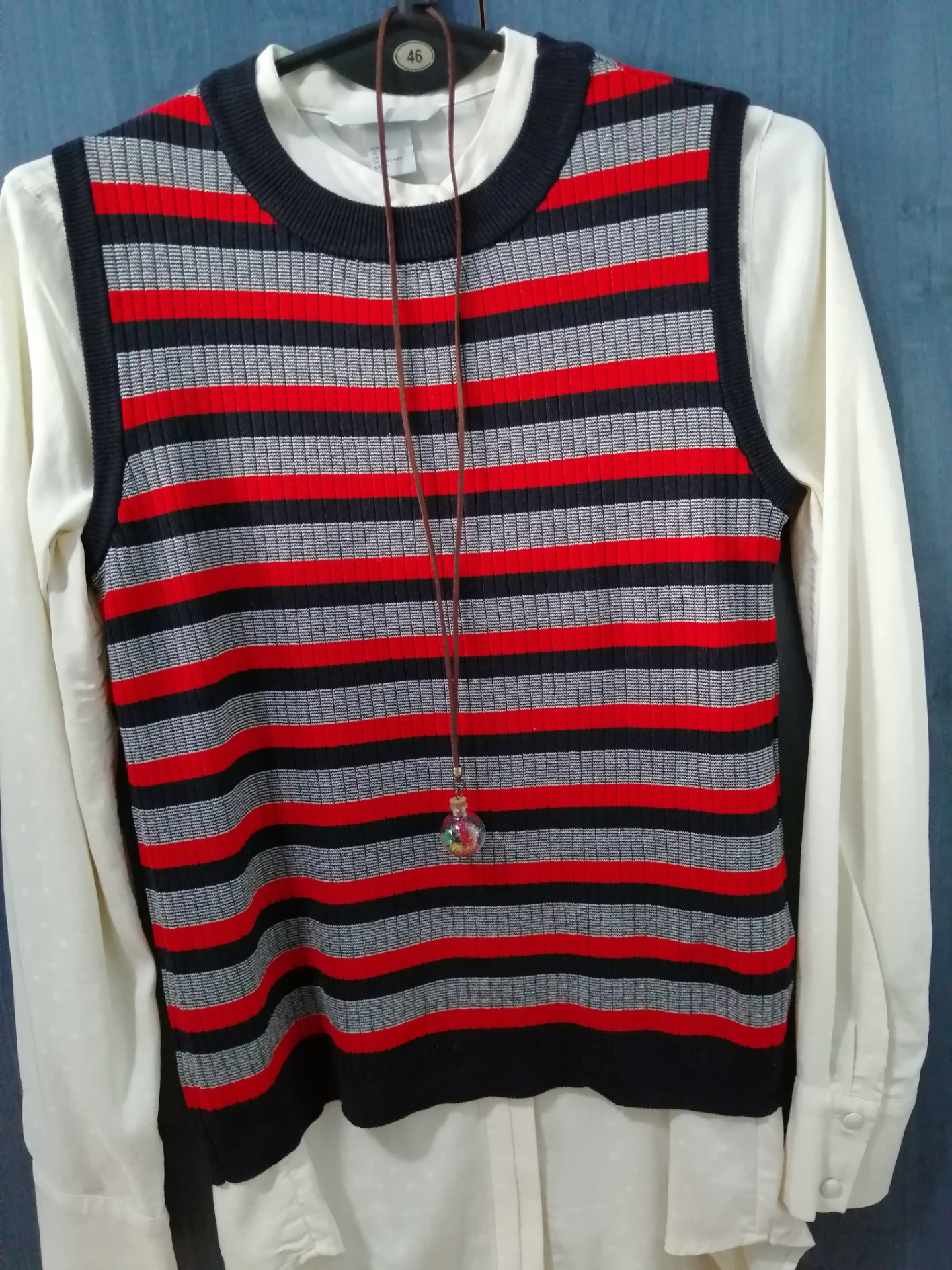 A white shirt with a striped vest